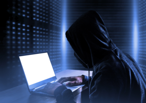 Image of a man using a computer system trying to hack into a small business account; the credit card data is protected because the business has PCI compliance