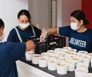 Image of volunteers handing out baked goods at a fundraising event
