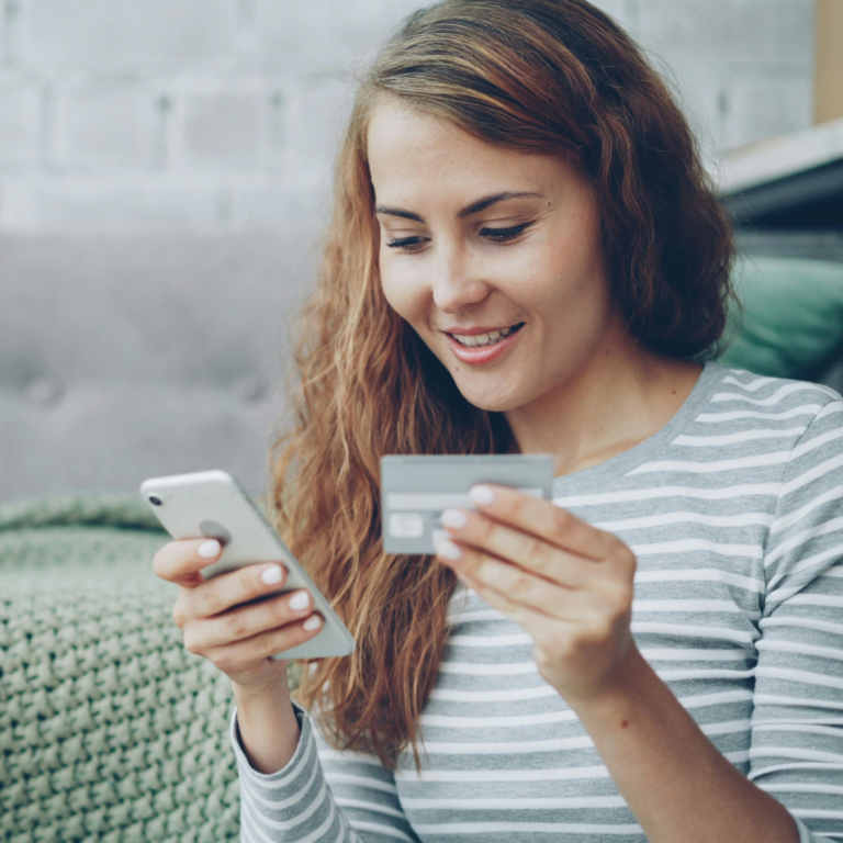 Image of a happy customer completing a credit card transaction from her mobile device